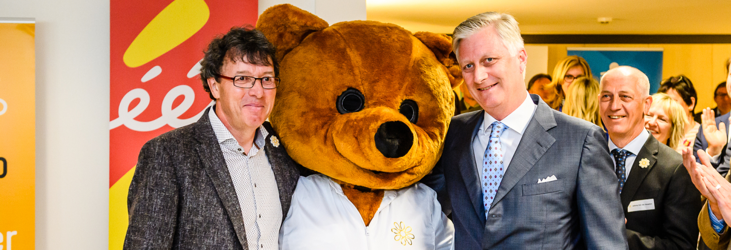 Koning Filip en Marc Michils bij de beer die knuffels uitdeelt voor 30 jaar Kom op tegen Kanker