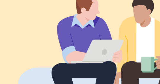 Twee mannen aan het werk met een laptop en een kop koffie