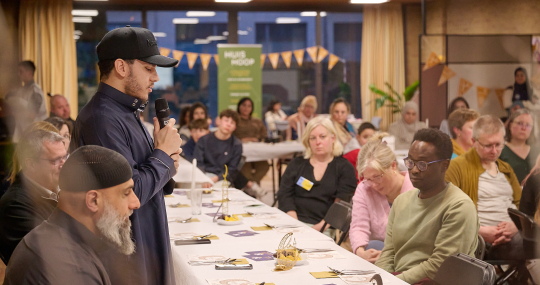 Jonge man spreekt de zaal toe tijdens de Life Iftars
